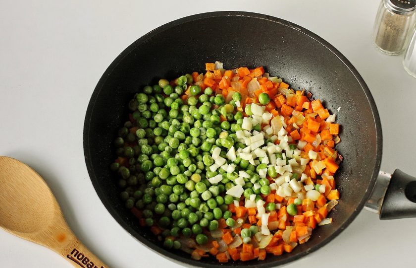 1. Этап. Жареный рис с яйцом: Обжарьте овощи до мягкости. Добавьте горошек и измельченный чеснок.