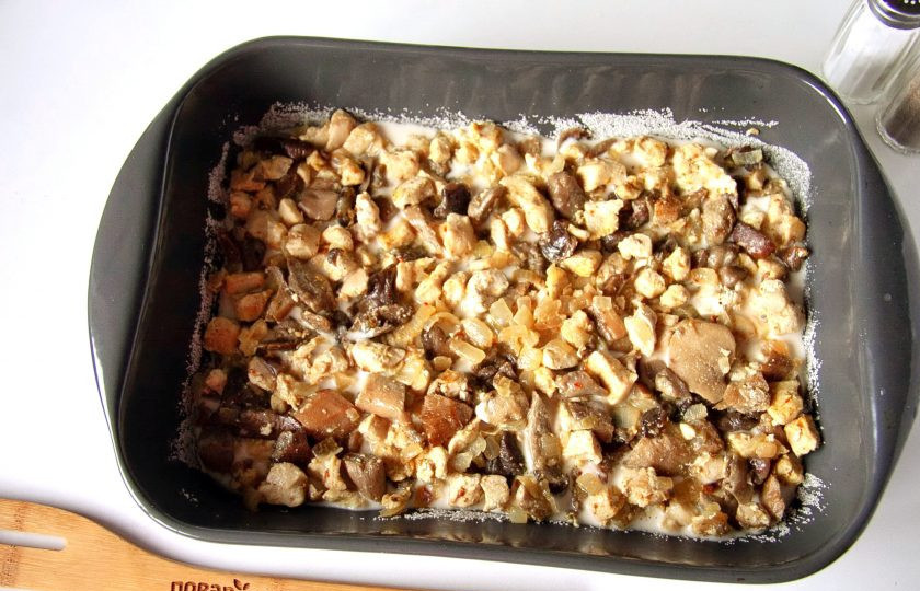 1. Этап. Заливной пирог с курицей и грибами: Форму для выпечки смажьте маслом. Дно и бока обсыпьте мукой или манкой. Вылейте примерно половину порции теста и сверху равномерно разложите начинку.