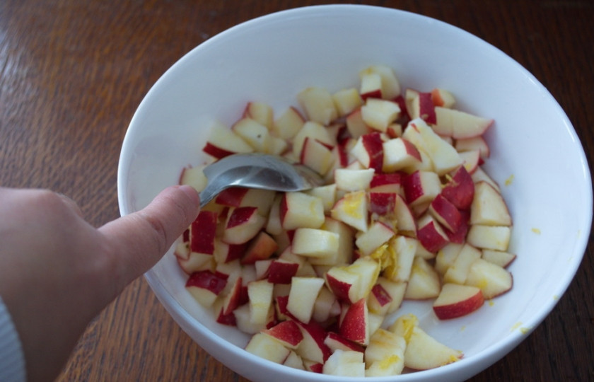 1. Этап. Яблочный пирог с изюмом: 7. Яблоки очистить от серединок. Нарезать кубиком. При помощи терки снимите с лимона цедру. После этого разрежьте лимон пополам и из половинки лимона выдавите сок на нарезанные яблоки. Перемешайте. Добавьте цедру.