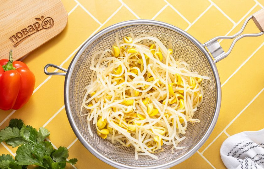 1. Этап. Салат из пророщенной сои по-корейски: Промойте ростки в холодной воде, откиньте на сито и дайте стечь лишней жидкости.