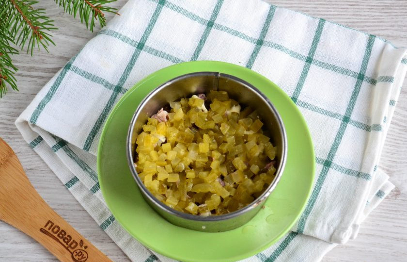 1. Этап. Мясной салат с орехами: Следом выложите нарезанные мелким кубиком огурцы.