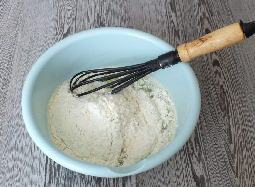 1. Этап. Хворост на сыворотке: Всыпьте половину муки и размешайте венчиком. Вторую часть всыпьте частями, каждый раз хорошо вымешивая.