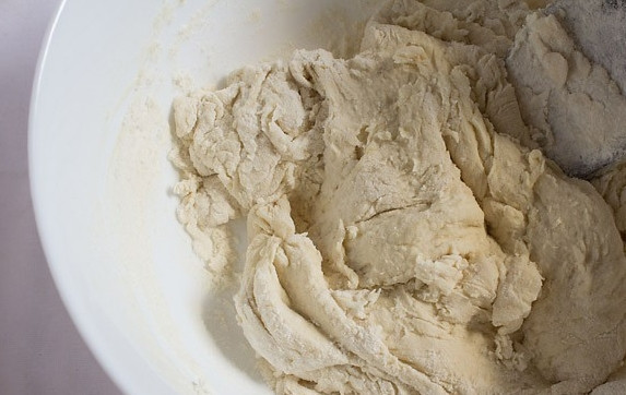 1. Этап. Пицца своими руками: Вымешивайте тесто, затем добавьте еще стакан муки и продолжайте вымешивать, чтобы тесто начало отходить от стенок миски.