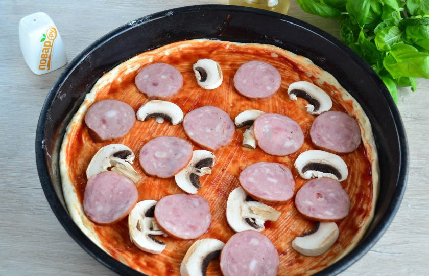 1. Этап. Пицца Каприччиозо: Выложите колбасу и грибы.