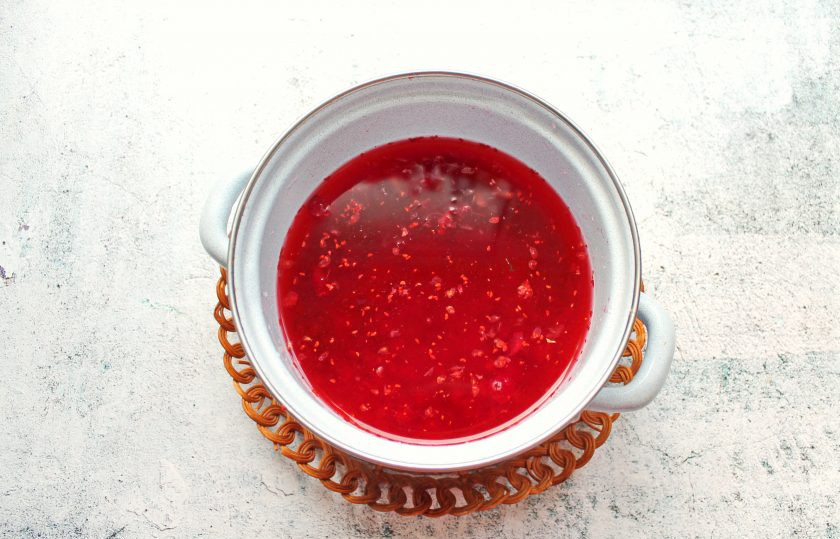 1. Этап. Клюквенный морс для детей: Клюквенный жмых выложите в эмалированную кастрюлю и залейте очищенной водой.