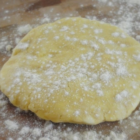 1. Этап. Пирог с черникой и персиками по-деревенски: Тесто достаем из холодильника, выкладываем на присыпанную мукой поверхность и раскатываем в круг диаметром около 30 см.