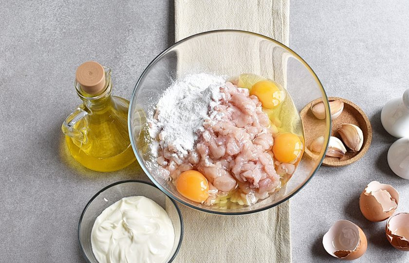 1. Этап. Оладьи из курицы: Разбейте в миску яйца, добавьте сметану. Посолите и поперчите массу по вкусу. Можно добавить любимые пряности или зелень.