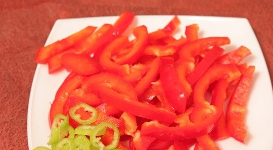 1. Этап. Запеченные кабачки с баклажанами: 4. Сладкий перец помыть, просушить и очистить от семян и хвостика. Нарезать небольшими брусочками. Острый перец вымыть и просушить. При желании очистить от семян, чтобы перец был не таким жгучим. Нарезать тоненькими кольцами или полукольцами.