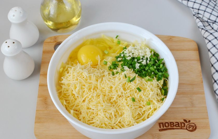 1. Этап. Вкусные картофельные драники: Добавьте тертый сыр (лучше на мелкой терке), яйцо, измельченный чеснок и зеленый лук.