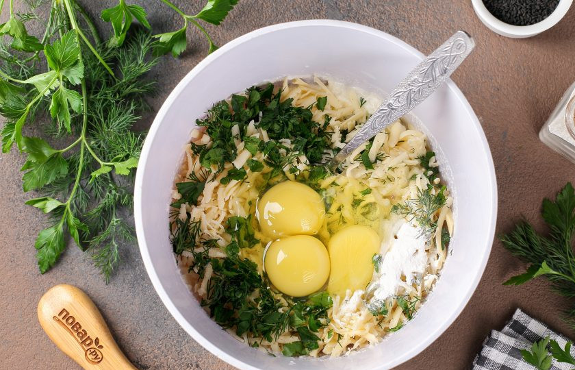 1. Этап. Манник с сыром: Добавьте измельчённую зелень, тёртый сыр, соль, разрыхлитель и яйца.