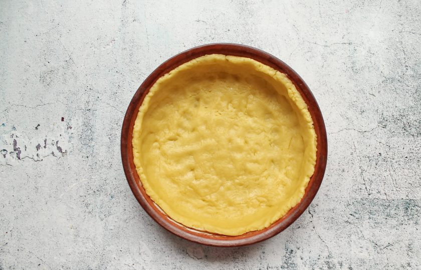 1. Этап. Ягодный пирог с маскарпоне: Тесто раскатайте в круг и выложите в форму диаметром 18 сантиметров, сделав до верха бортики. Наколите вилкой тесто в основании.