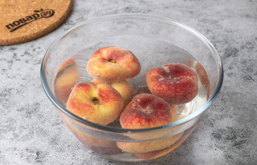 1. Этап. Варенье из инжирных персиков: Персики помойте, затем залейте горячей водой и оставьте на пару минут.