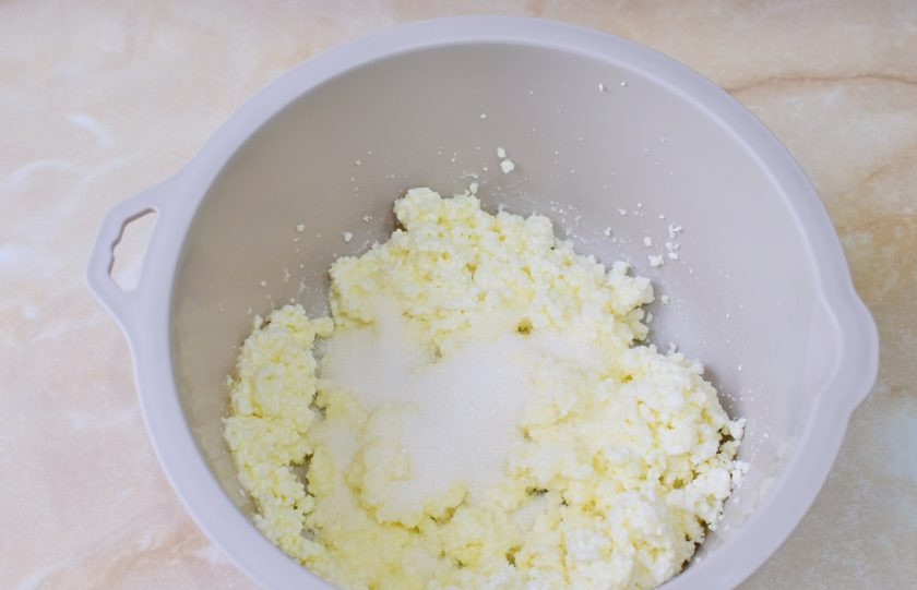 1. Этап. Творожные лепешки в духовке: Добавьте соль и сахар. Разомните вилкой.
