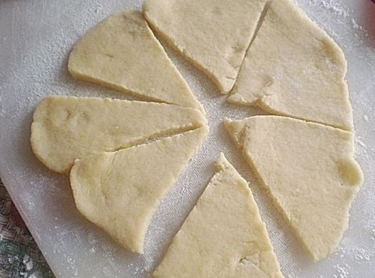 1. Этап. Рулетики с джемом: Тесто раскатайте лепёшками в 4-5 мм. толщиной. Нарежьте их небольшими треугольниками.