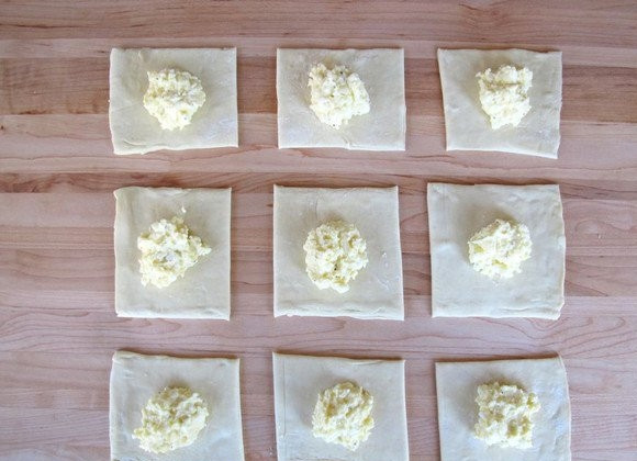 1. Этап. Слойки из бездрожжевого теста с сыром: 3. Выложите начинку в центр каждого квадратика теста.