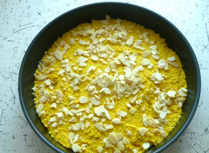 1. Этап. Веганский пирог с кокосом: Форму для выпекания (24-26 см) при необходимости смажьте небольшим количеством оливкового масла. Для этого удобно использовать бумажные салфетки. Выложите тесто и разровняйте его лопаткой. Сверху посыпьте миндальные лепестки и выпекайте 40 минут при 180°. Готовность можно проверить зубочисткой – она должна выходить сухой.