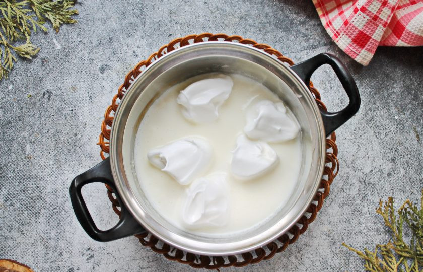 1. Этап. Снежки из белков: В широкой кастрюле смешайте ванильный сахар, сливки и молоко, добавьте сахар, перемешайте и доведите до кипения, убавьте огонь. Чайной или столовой ложкой берите часть вбитых белков, стараясь придать форму шара, и опускайте в кипящее молоко. Варите их в течение от 30 секунд до 1 минуты. Как только безе увеличилось, переверните и готовьте еще 30 секунд. Готовые белки достаньте и выложите на сито. чтобы стекло молоко.