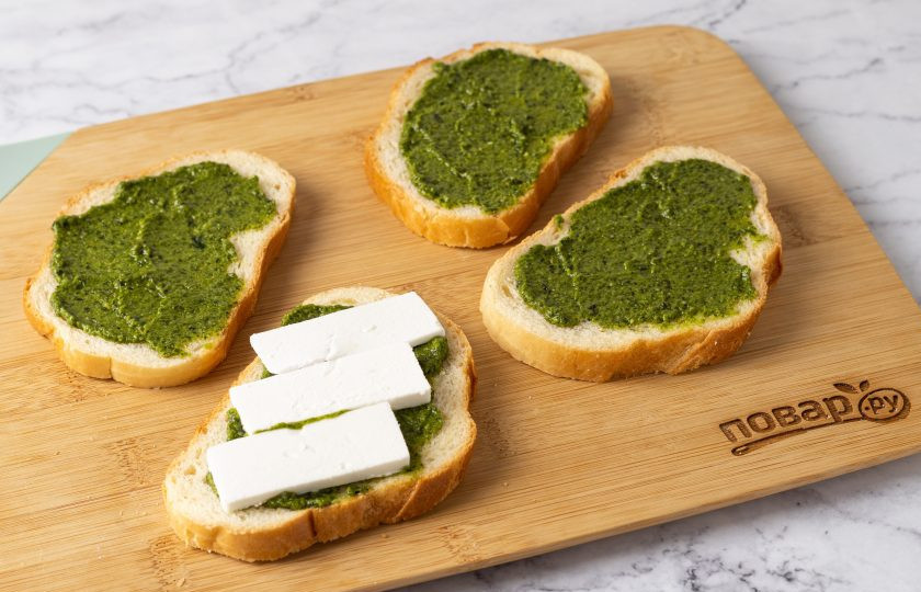 1. Этап. Сэндвич Капрезе: Смажьте ломтики хлеба соусом Песто. Выложите ломтики сыра.