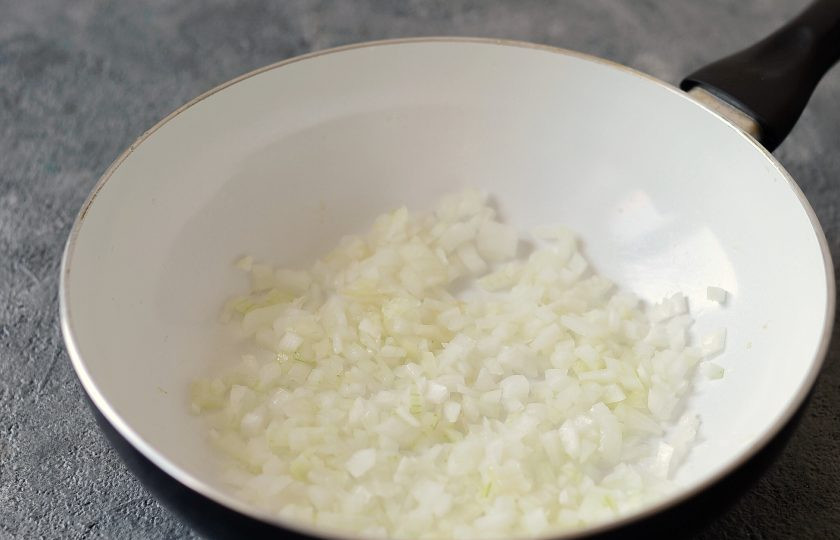 1. Этап. Беляши с грибами: Лук очистите и нарежьте на мелкие кубики. Обжарьте на сковороде до прозрачности.