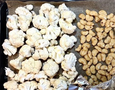 1. Этап. Суп-пюре из цветной капусты: Помыть капусту, удалить листья и разобрать на соцветия. Положить на противень, застеленный бумагой для выпечки. Посыпать 1 ч. ложкой соли, полить 3 ст. ложками оливкого масла. Фасоль слить, дать стечь жидкости (не выливайте, из неё получается отличный майонез). Посыпать фасоль хариссой, положить на противень. Чеснок очистить от шелухи, обрезать слегка верхушку, сбрызнуть 1 ст. ложкой масла. Завернуть в фольгу и тоже положить на противень. На фото чеснок открытый, чтобы было видно, что в фольге. Запекать 30 минут.