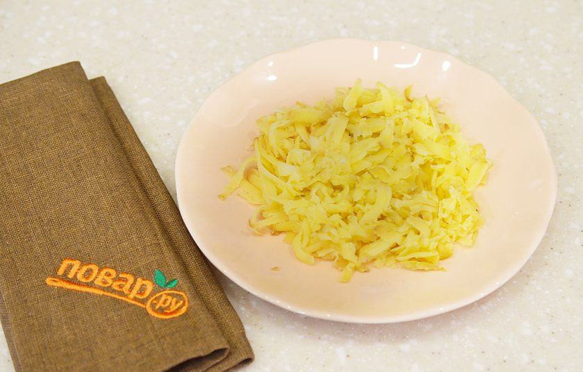 1. Этап. Новогодний салат Хрюшка: 1. Картофель натрите на терке и выложите первым слоем. Промажьте майонезом.