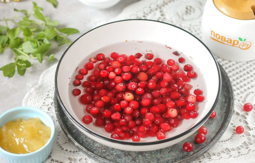 1. Этап. Медово-клюквенный конфитюр: Клюкву пересыпьте в глубокую емкость и залейте холодной водой. Тщательно промойте и удалите веточки, стебельки и прочий мусор.