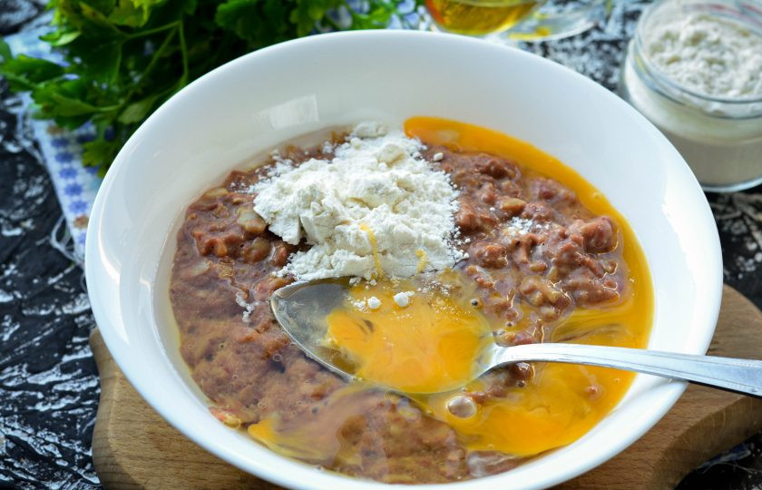 1. Этап. Котлеты из куриных потрохов: Всыпьте в фарш соль, перец, муку и вбейте куриное яйцо. Перемешайте заготовку.