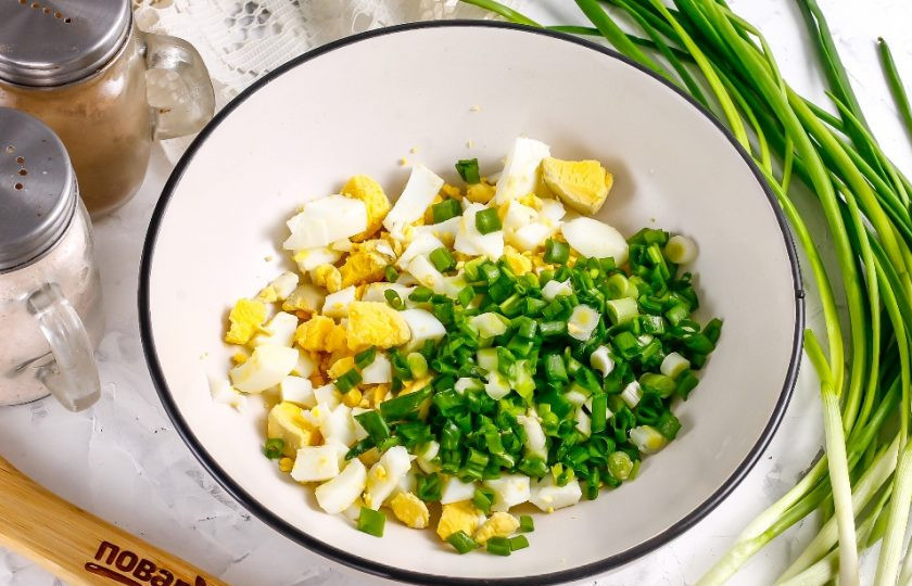 1. Этап. Салат из свиного сердца: Очистите отварные куриные яйца от скорлупы, промойте в воде и нарежьте мелкими кубиками. Промойте стебли зеленого лука, измельчите их и всыпьте в глубокую емкость вместе с яичной нарезкой.