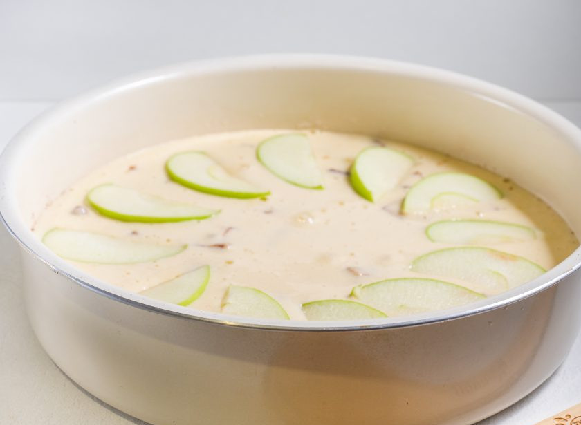 1. Этап. Шарлотка с яблоками с хрустящей корочкой: Отложенную половинку яблока нарежьте тонкими дольками и выложите сверху.