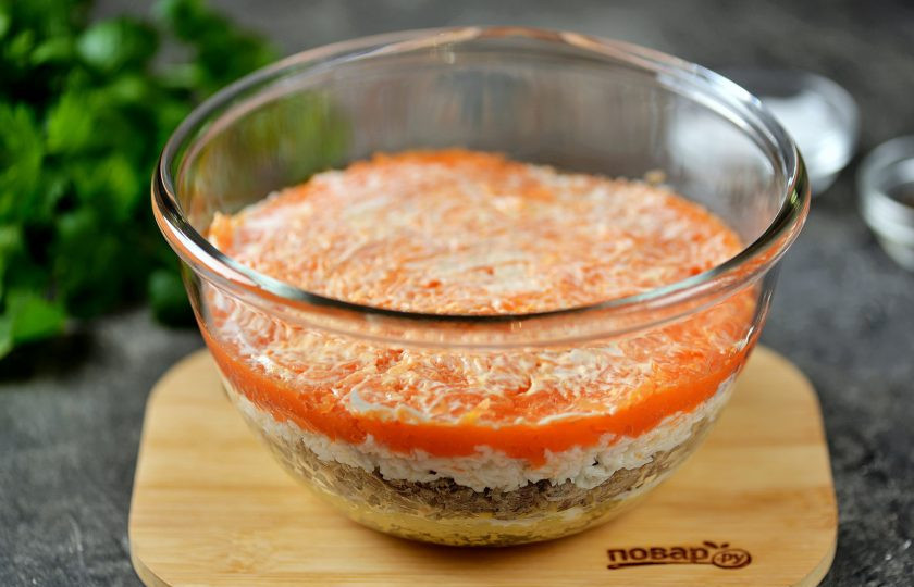 1. Этап. Салат Мимоза классический: Сверху на белки выложить натёртую морковь и опять смазать небольшим слоем майонеза.