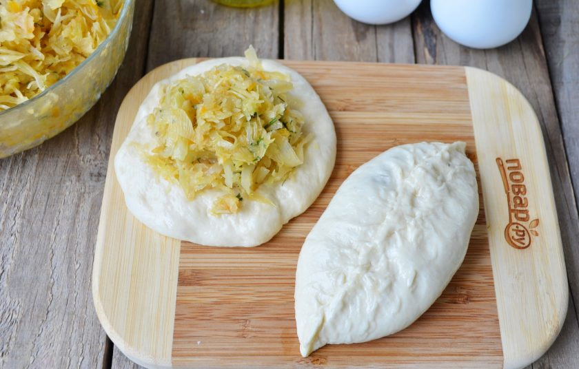 1. Этап. Пирожки с капустой (мастер-класс): На смазанном маслом столе раскатывайте пальцами комочек теста, в центр положите начинку из жареной капусты. Защипните плотно край. Дайте пирожкам минут 10 подойти.