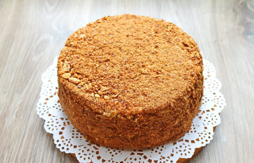 1. Этап. Польский медовик: Обсыпьте торт со всех сторон крошкой из обрезков. Уберите в холодильник на 6 часов для пропитывания.