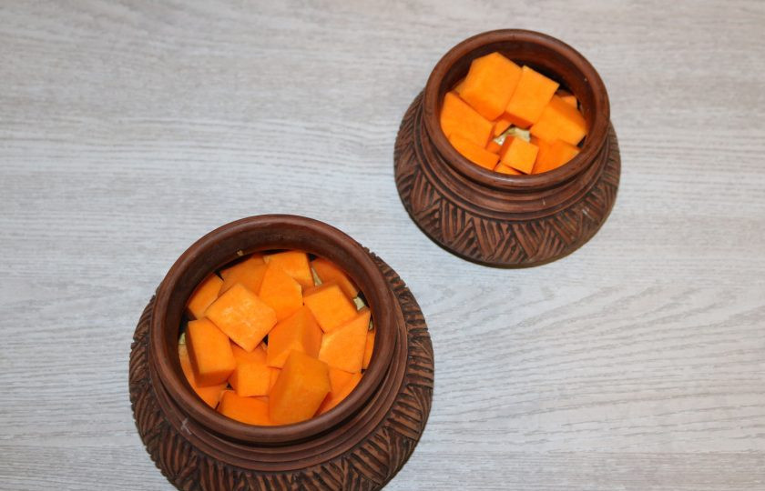 1. Этап. Курица с тыквой в горшочке: Сверху выложите нарезанную тыкву.