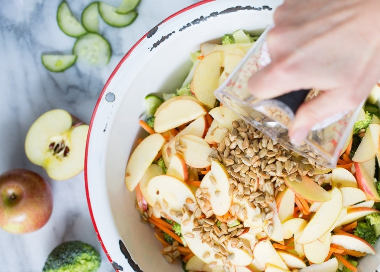 1. Этап. Салат из свежей капусты с яблоком: 3. Яблоки (у меня одно сладкое и одно кислое) мою и разрезаю пополам, затем вычищаю семена и нарезаю тонкими дольками. Добавлю в салатник яблоки вместе с семечками подсолнуха.