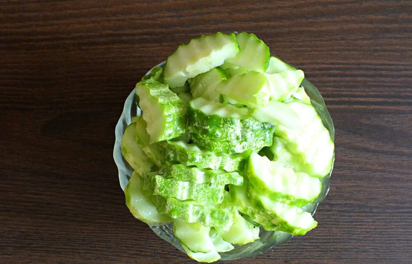 1. Этап. Салат Зимняя сказка на зиму: Нарежьте огурцы половинками кругляшков. Если у вас очень крупные огурцы, разрежьте на четвертинки.