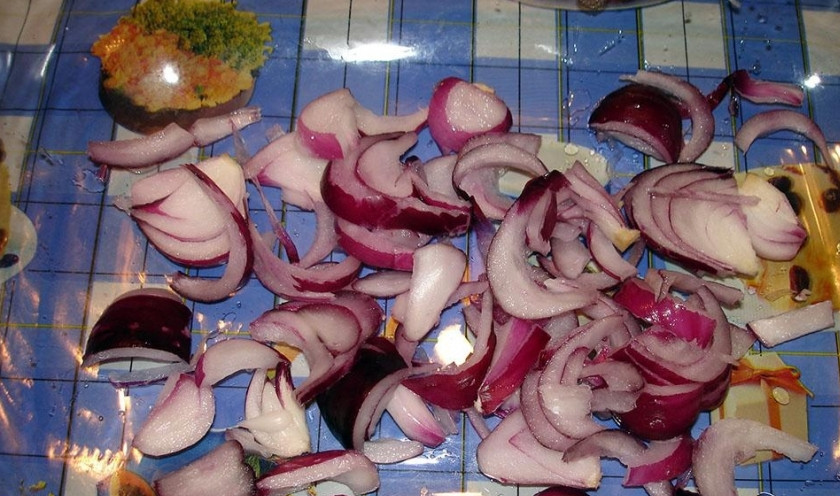 1. Этап. Бедро индейки с овощами: Лук порежьте полукольцами. Форму для запекания смажьте слегка маслом, выложите в неё лук.