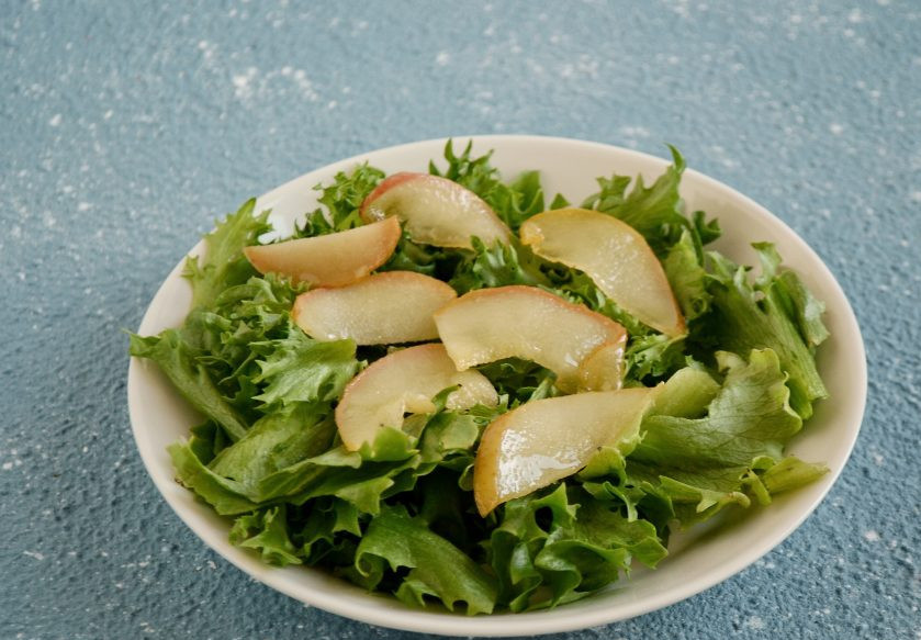 1. Этап. Салат с карамелизированной грушей: Выложите в тарелку салатные листья, затем грушу и тертый сыр. Сверху посыпьте орехами.