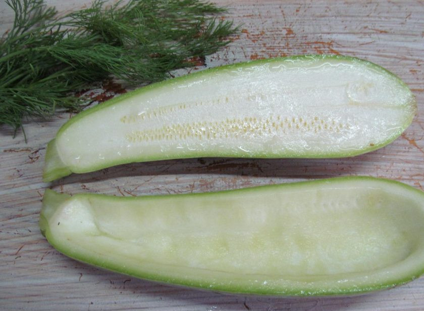 1. Этап. Кабачки с рисом и грибами: Кабачок разрежьте вдоль на две части, с помощью ложки выньте внутреннюю часть — мякоть. Она нам больше не понадобится. Из мякоти можно приготовить смузи, гаспачо, ее можно добавить в борщ или суп.