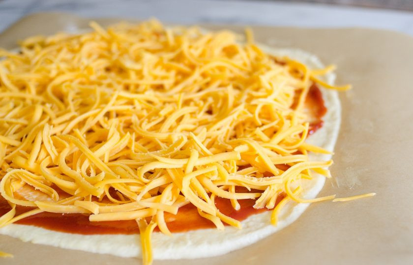 1. Этап. Начинка для пиццы с фаршем: 6. Натрите на крупной терке сыр и посыпьте им пиццу поверх кетчупа.