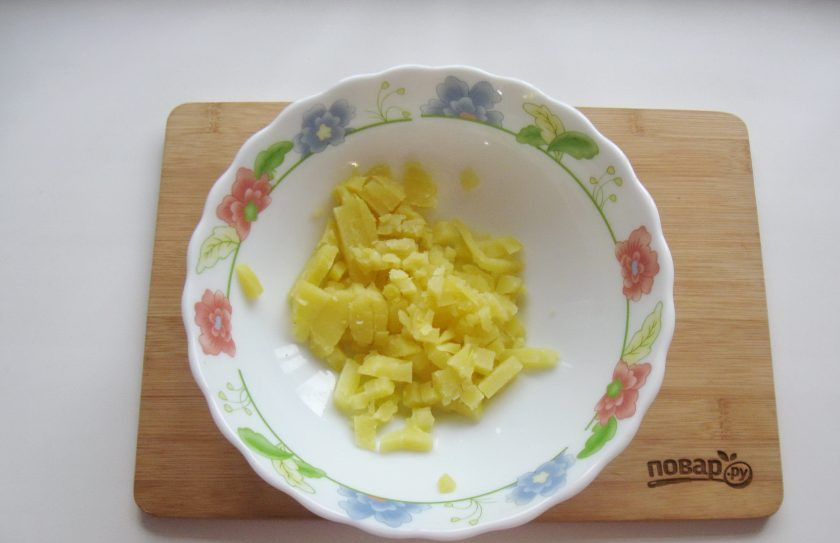 1. Этап. Оливье с курицей и яблоком: Картофель отварите в кожуре, охладите и очистите. Нарежьте мелкими кубиками и выложите в салатник.