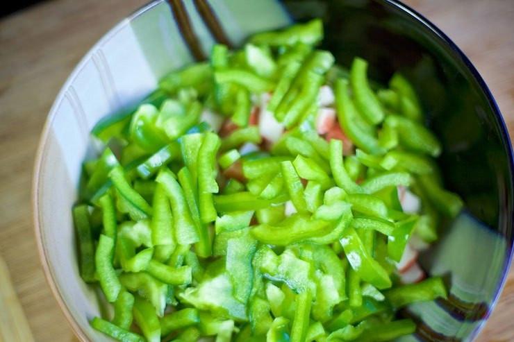 1. Этап. Cалат с крабовыми палочками и фасолью: Болгарский перец очистите от семян. Нарежьте и добавьте к крабовым палочкам.