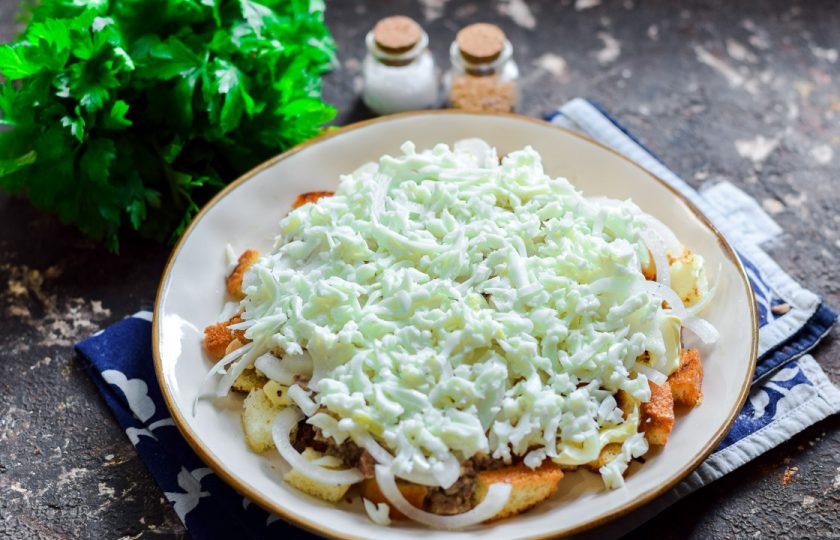 1. Этап. Салат Одуванчик с рыбными консервами: Куриные яйца отварите и почистите от скорлупы. Белки натрите на терке и уложите поверх лука.