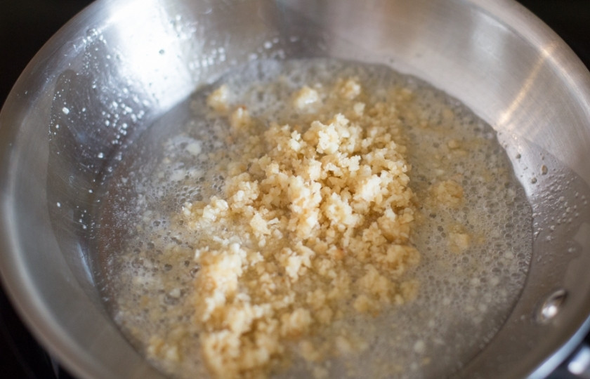 1. Этап. Курица по-тайски: Сначала сделаем соус. Поставьте небольшую кастрюлю на средний огонь. Растопите в ней сливочное масло (1 ст. ложка), затем бросьте туда давленный чеснок и измельчённые орешки (50 грамм). Жарьте всё одну минутку.