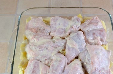 1. Этап. Картофель с курицей в духовке: Выложите курицу поверх картофеля. Оставьте всё мариноваться на 30 минут.