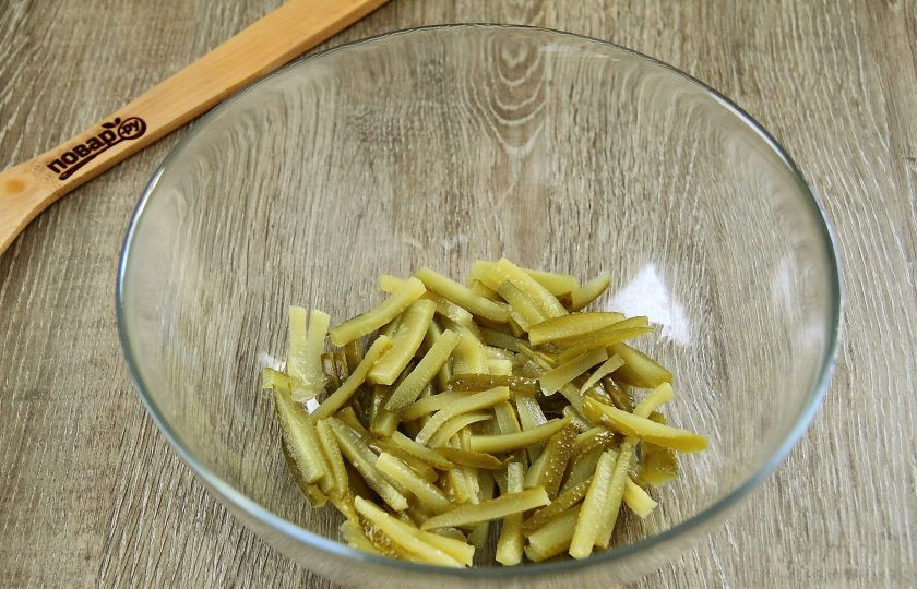 1. Этап. Салат Лисичка с корейской морковкой: Нарежьте огурцы небольшой соломкой и выложите в салатницу.