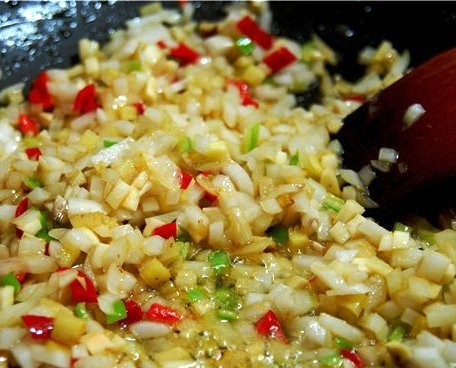 1. Этап. Зеленое карри из курицы с ананасами: Вновь разогреваем вок, в котором жарилась курица. Бросаем туда чеснок (его крупно нарежем), перцы, лук (его нарежем мелко) и имбирь. Перемешиваем и обжариваем 1 минуту.