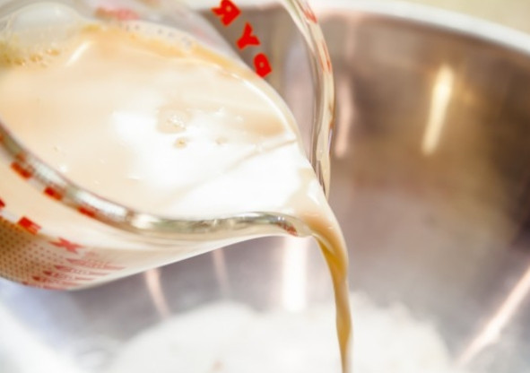 1. Этап. Оладьи на топленом молоке: Первым делом смешайте все сухие ингредиенты. И начинайте вливать к ним молоко, помешивая венчиком.