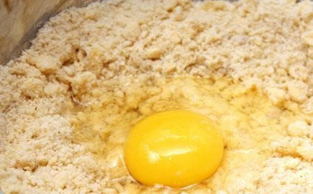 1. Этап. Миндальный пирог: 2. В перебитую смесь добавьте одно куриное яйцо. Влейте пару столовых ложек рома. Теперь быстро и основательно перемешайте. Тесто положите в пищевую пленку. Поставьте в холодильник на 30 минут.