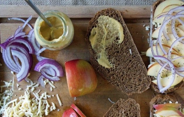 1. Этап. Сэндвич с сыром, яблоком и луком: 1. Вымойте и обсушите яблоко, нарежьте его тонкими ломтиками. Полукольцами нарежьте лук. Два ломтика хлеба смажьте горчицей по вкусу.