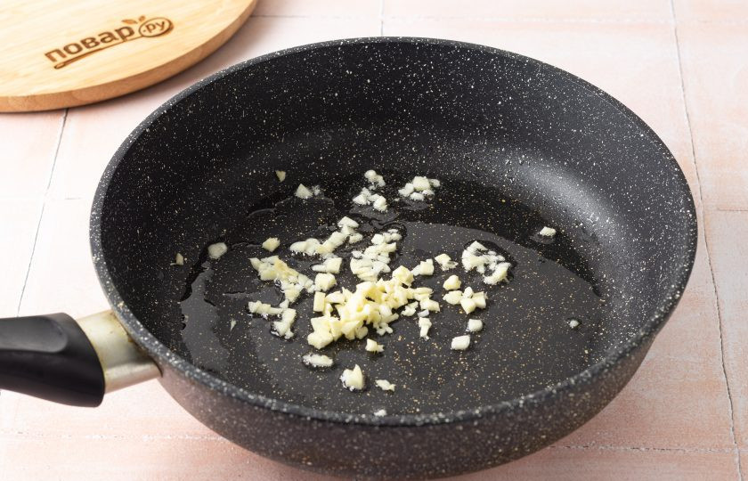 1. Этап. Зеленый гарнир: Разогрейте сковороду с растительным маслом на среднем огне. Чеснок мелко порубите и слегка обжарьте до раскрытия аромата.